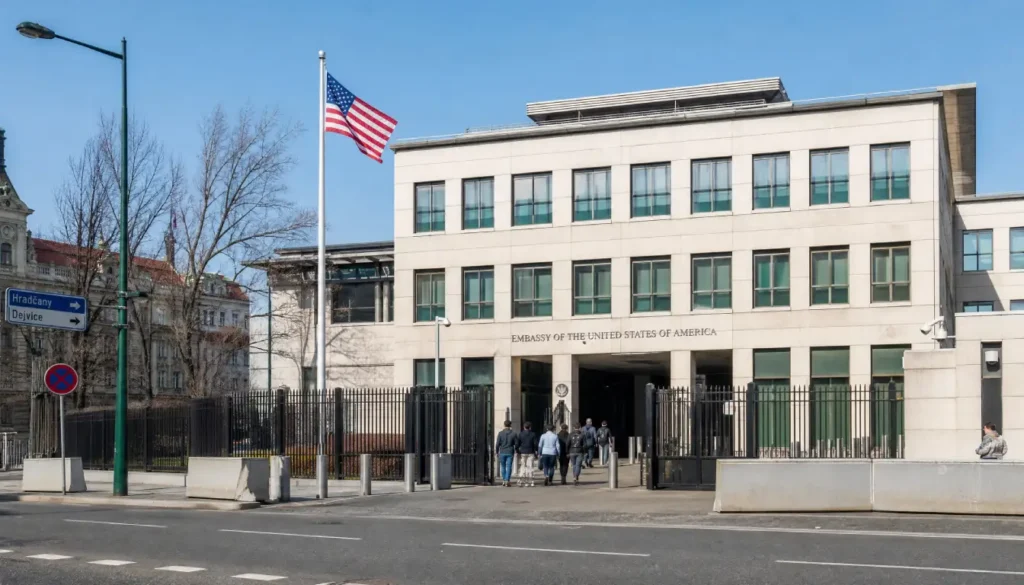Exterior view of a US embassy building abroad with an American flag, where travelers can get emergency passport help